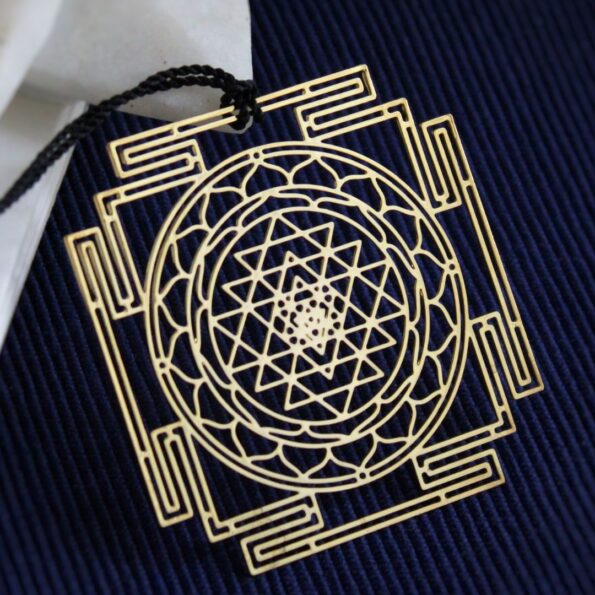 Brass Shree Yantra geometric bookmark with intricate sacred geometry and black tassel.