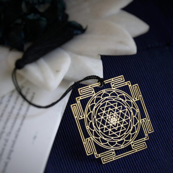 Brass Shree Yantra geometric bookmark with intricate sacred geometry and black tassel.